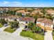 Neighborhood aerial view of a two-story home with a tile roof and manicured lawns at 5283 Wildwood Way, Davenport, FL 33837