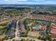 Aerial view featuring a community pool, tennis court, and clubhouse surrounded by lush landscaping at 5283 Wildwood Way, Davenport, FL 33837