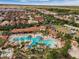 Aerial view of a community pool, lazy river, and clubhouse with lots of greenery at 5283 Wildwood Way, Davenport, FL 33837