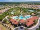 Aerial view of community pool, lazy river and clubhouse surrounded by lush landscaping at 5283 Wildwood Way, Davenport, FL 33837