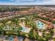 Aerial view of a community with a pool, lazy river, tennis court, and green landscaping at 5283 Wildwood Way, Davenport, FL 33837