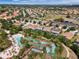 An aerial view shows a lazy river and pool surrounded by homes and lush landscaping at 5283 Wildwood Way, Davenport, FL 33837