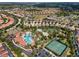 An aerial view shows a community pool, lazy river, and clubhouse surrounded by homes at 5283 Wildwood Way, Davenport, FL 33837