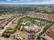 Aerial view of a lush community featuring a pool, lazy river, and a tennis court at 5283 Wildwood Way, Davenport, FL 33837