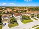 Neighborhood aerial view of a two-story home with a tile roof and manicured lawns at 5283 Wildwood Way, Davenport, FL 33837