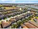 An aerial view of a residential neighborhood with tile roofs, lakes, and mature trees on a sunny day at 5283 Wildwood Way, Davenport, FL 33837