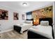 Twin beds dressed in white duvets in a bedroom that features brick-patterned Mickey Mouse wall art at 5283 Wildwood Way, Davenport, FL 33837