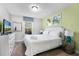 Cozy bedroom featuring a TV, bright green accent wall, and comfortable white bed at 5283 Wildwood Way, Davenport, FL 33837