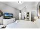 Bright bedroom featuring a television, white dresser, and access to the ensuite bathroom and walk-in closet at 5283 Wildwood Way, Davenport, FL 33837