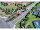 Aerial view of the community entrance with lush landscaping, palm trees, and tile-roofed guard house at 5283 Wildwood Way, Davenport, FL 33837