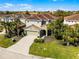 A two-story home with a tile roof, well-manicured lawn, and tropical landscaping at 5283 Wildwood Way, Davenport, FL 33837