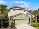 Two-story home with a tile roof, two-car garage, and lush landscaping and Mickey Mouse emblems on the gables at 5283 Wildwood Way, Davenport, FL 33837