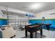 A recreational room with foosball table, shuffleboard, table and chairs, with blue and green walls and white ceiling at 5283 Wildwood Way, Davenport, FL 33837