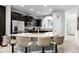 Well-lit kitchen featuring dark cabinets, granite countertops, stainless steel appliances, and bar stool seating at 5283 Wildwood Way, Davenport, FL 33837