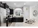 Modern kitchen showcasing dark cabinetry, stainless steel appliances, granite countertops, and an archway at 5283 Wildwood Way, Davenport, FL 33837