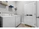 Laundry room with white washer and dryer, overhead shelving, and a door with 'no exit' sign at 5283 Wildwood Way, Davenport, FL 33837