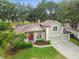 Aerial view of a charming two-story home with a red front door, three-car garage, and well-kept landscaping at 600 Statenville Ct, Ocoee, FL 34761