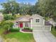 Aerial view of a charming two-story home with a red front door, three-car garage, and well-kept landscaping at 600 Statenville Ct, Ocoee, FL 34761