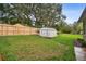 Backyard features a storage shed near a new wooden fence and mature trees at 600 Statenville Ct, Ocoee, FL 34761