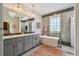 Luxurious bathroom with double vanity, modern lighting, elegant tub, and grey color palette at 600 Statenville Ct, Ocoee, FL 34761