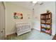 Bedroom with a crib, bookshelf, and decorative accents at 600 Statenville Ct, Ocoee, FL 34761