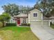 Charming two-story home with a well-manicured lawn, red front door, and three-car garage at 600 Statenville Ct, Ocoee, FL 34761