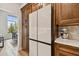 Bright kitchen featuring white 4-door refrigerator and dark wood cabinets at 600 Statenville Ct, Ocoee, FL 34761