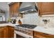 Gourmet kitchen with a stainless steel stove, decorative tile backsplash, and wooden cabinets at 600 Statenville Ct, Ocoee, FL 34761