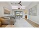 Bright living room featuring a gray sectional, tray ceiling, and light wood floors at 600 Statenville Ct, Ocoee, FL 34761