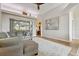 Bright living room featuring a gray sectional, tray ceiling, and light wood floors at 600 Statenville Ct, Ocoee, FL 34761