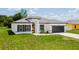 Charming one-story home boasts a modern exterior design, lush green lawn, and well-manicured landscaping at 6164 Sw 129Th St, Ocala, FL 34473