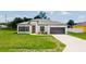 Modern exterior elevation showcasing the well-maintained lawn and neutral color palette with attractive gray trim at 6164 Sw 129Th St, Ocala, FL 34473