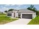 Stylish home featuring a paved driveway, two car garage and meticulously maintained lawn at 6164 Sw 129Th St, Ocala, FL 34473