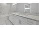 This bathroom offers a double vanity with white cabinets, quartz countertop, and sleek fixtures at 62 W Jersey St # 13, Orlando, FL 32806