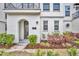 Close up of a townhome exterior with lush landscaping and a modern arched entryway at 62 W Jersey St # 13, Orlando, FL 32806