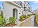 Charming townhome featuring an arched entryway and wrought iron balcony, complemented by lush landscaping at 62 W Jersey St # 13, Orlando, FL 32806