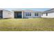 Exterior of house with a large green lawn and screened-in back porch at 6403 Shimmering Shores Ln, St Cloud, FL 34771