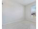 Bright, empty bedroom with neutral tile flooring and natural light streaming through the window at 6403 Shimmering Shores Ln, St Cloud, FL 34771