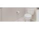 Close-up of a white toilet with neutral walls and floors at 6403 Shimmering Shores Ln, St Cloud, FL 34771