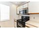 Modern kitchen featuring a stainless steel microwave and black appliances, complemented by a window for natural light at 645 Stafford Ter # 162, Altamonte Springs, FL 32714