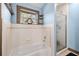 Cozy bathroom featuring a tub with tile surround and a glass-enclosed shower with a small window at 7279 Nena Ct, Mount Dora, FL 32757