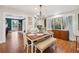 Elegant dining room featuring a wood table, bench, and a chandelier, with view into living area at 7279 Nena Ct, Mount Dora, FL 32757