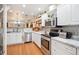 Charming kitchen features white cabinetry, stainless steel appliances, and marble countertops at 7279 Nena Ct, Mount Dora, FL 32757