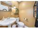 Cozy powder room with pedestal sink, decorative mirror, and stylish light fixture at 7279 Nena Ct, Mount Dora, FL 32757