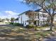 Charming two-story condo with white exterior, black shutters, and a cozy balcony, surrounded by lush landscaping at 7548 Gathering Dr, Reunion, FL 34747