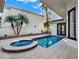 Backyard pool with a spa, surrounding pavers and manicured landscaping around the perimeter at 7548 Gathering Dr, Reunion, FL 34747