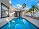 View of the pool featuring a spa, tiled steps, and a spacious outdoor patio at 7548 Gathering Dr, Reunion, FL 34747