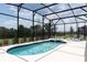 Outdoor screened-in pool and spa with tile accents offers relaxation and privacy at 7699 Oakmoss Loop, Davenport, FL 33837