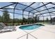 Screened-in pool with attached spa and lounge chairs offers a relaxing outdoor retreat at 7699 Oakmoss Loop, Davenport, FL 33837