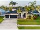 Aerial view of a charming home with a three-car garage, manicured lawn, and palm trees in a quiet neighborhood at 814 Chamberlin Trl, St Cloud, FL 34772